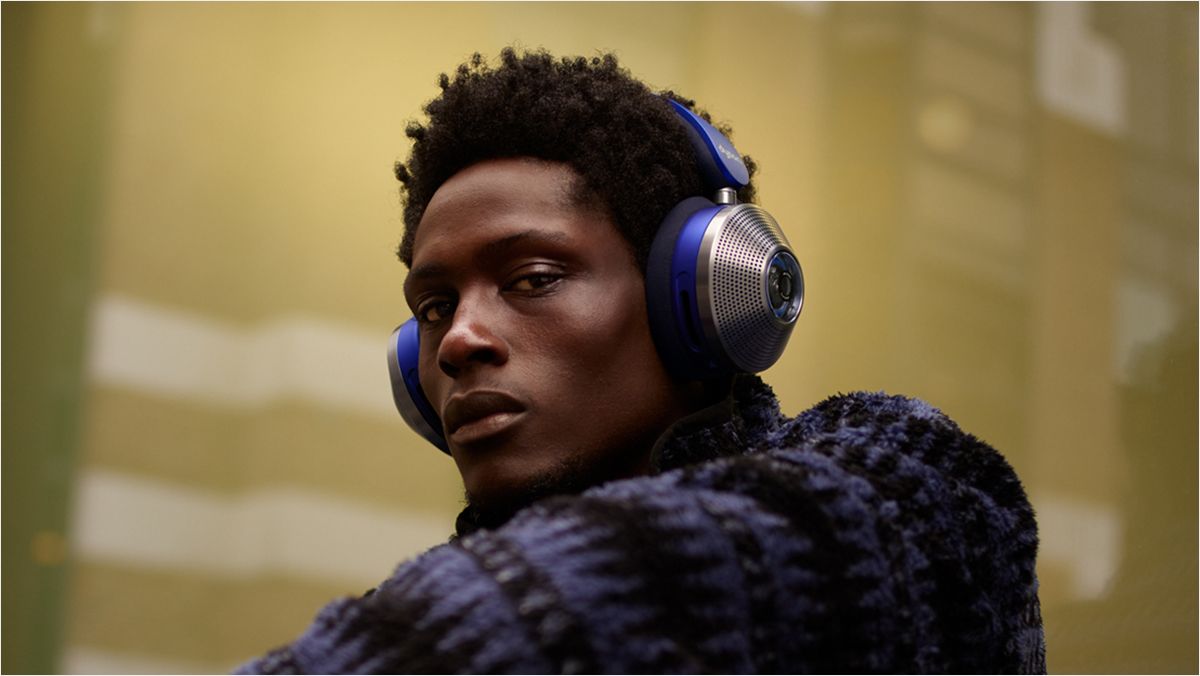 Un mannequin assis contre une fenêtre en ville et portant son casque à réduction de bruit Dyson Zone.